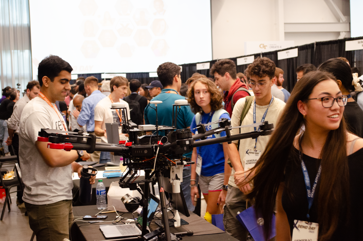 A busy exhibition floor with attendees exploring booths and demos at a Georgia Tech innovation and entrepreneurship event.