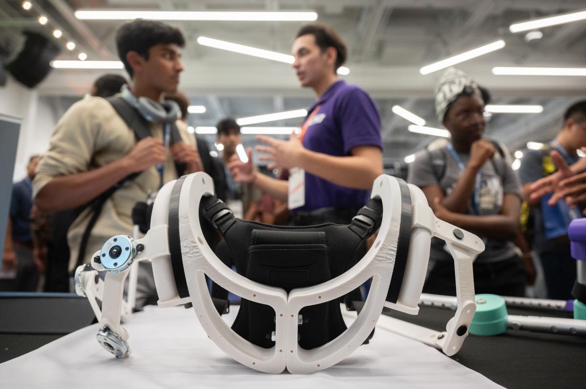 students in the background and a close up of a device